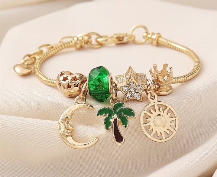 Pulsera tipo charm dorada con dijes celestiales y tropicales
